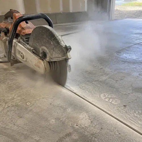 Control joint being saw cut into a cured concrete floor