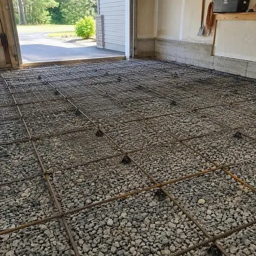 Compacted gravel base and wire mesh ready for a garage concrete floor pour