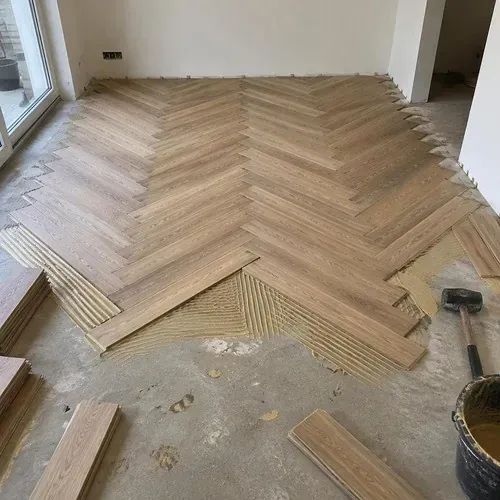 Herringbone wood floor being installed outward from a centre line