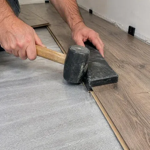 Laminate plank tapped into place in an Acton rental unit