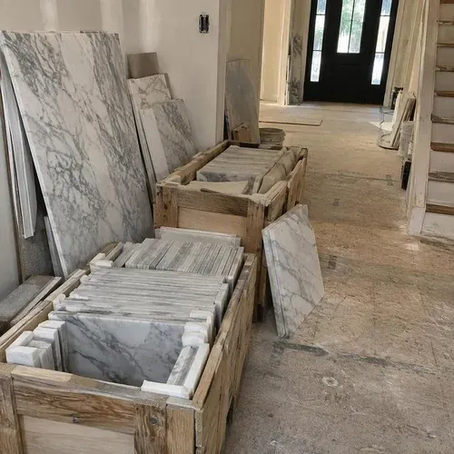 Crated marble floor tiles staged in an entryway for dry layout