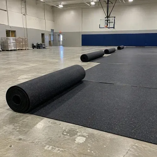 Rubber shock underlay rolled out across a gym for a sports floor system