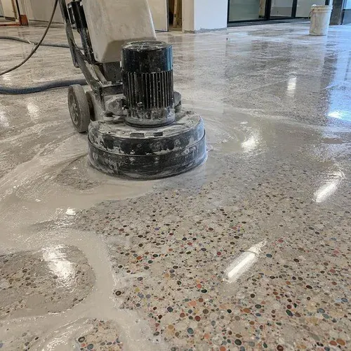 Floor grinder polishing cured terrazzo with slurry on the surface